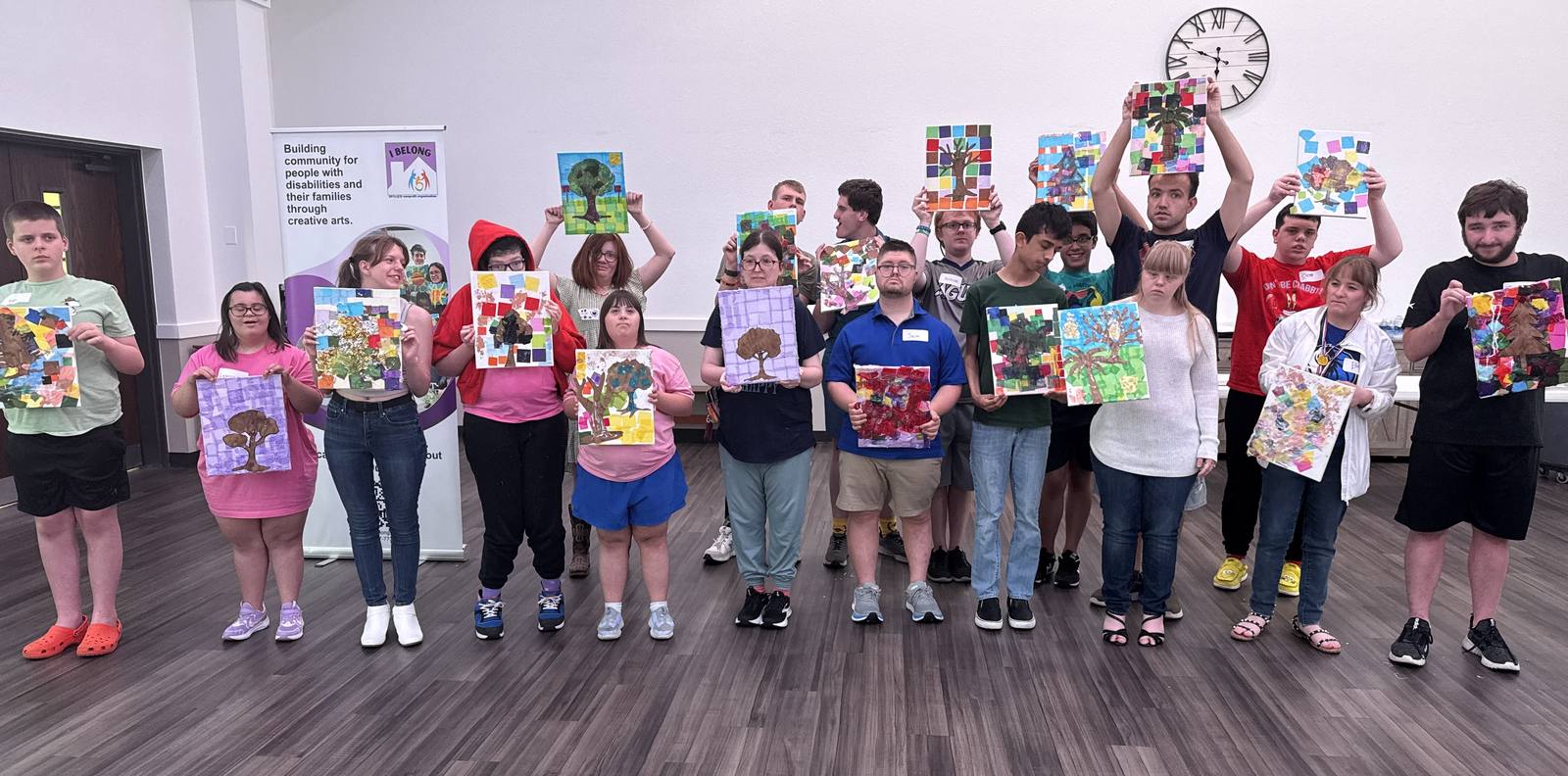 I Belong creators holding their artwork together